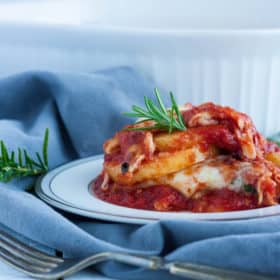 a plate of gluten free lasagna on a grey cloth