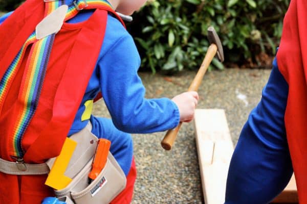 a child nailing a hammer to build a raspberry support