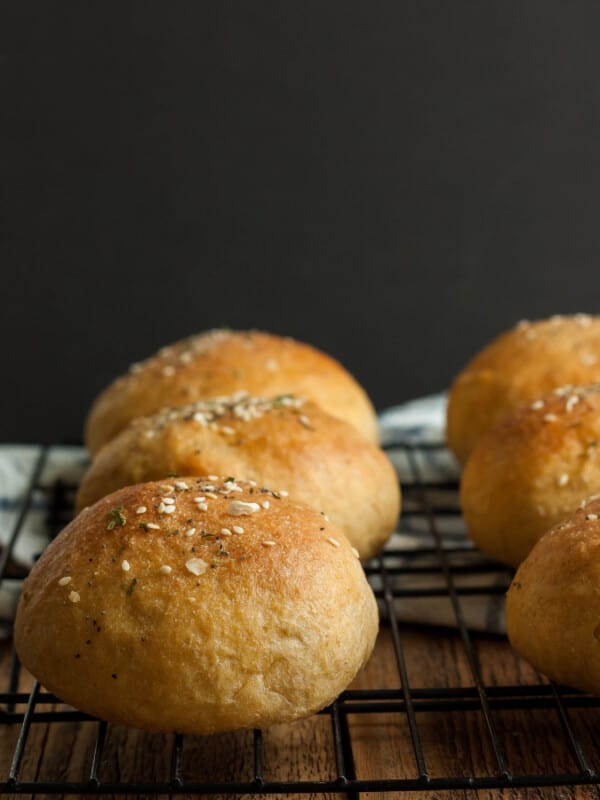 whole wheat hamburger buns on a baking rack against a black background