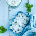 A tin of homemade mints with mint sprigs