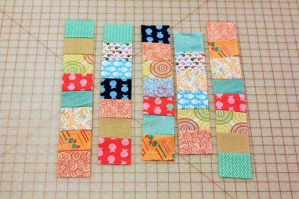 individual strips of fabric laid out on a cutting mat for beginner quilts