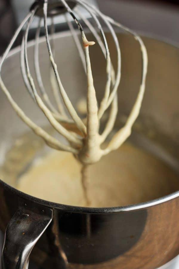 a mixer whisk propped up with madeleine batter