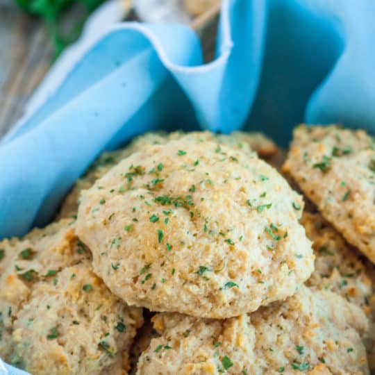 homemade red lobster cheddar bay biscuits in a basket with a blue linen