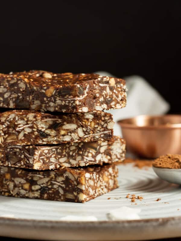 Four trail mix bars stacked on a plate