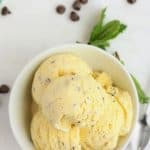 mint chocolate chip ice cream in a bowl on a white surface