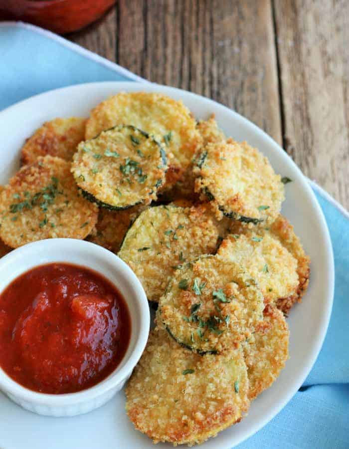 fried zucchini chips on a white plate with marinara