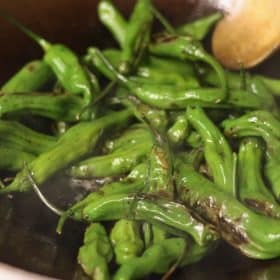 blistered shishito peppers in a wok | sustainablecooks.com
