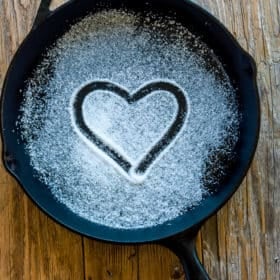 a cast iron skillet with a heart drawn in salt