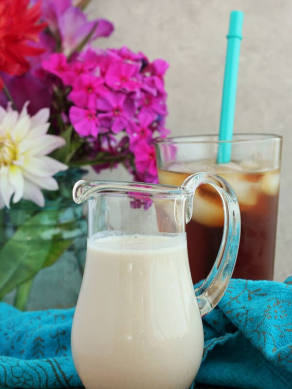 sugar-free coffee creamer in a glass pitcher with flowers and ice coffee