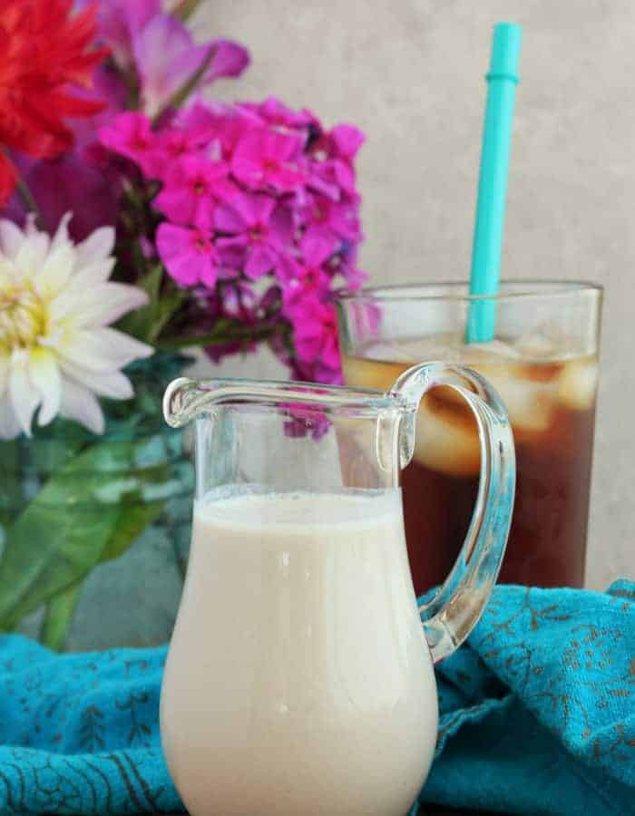sugar-free coffee creamer in a glass pitcher with flowers and ice coffee 