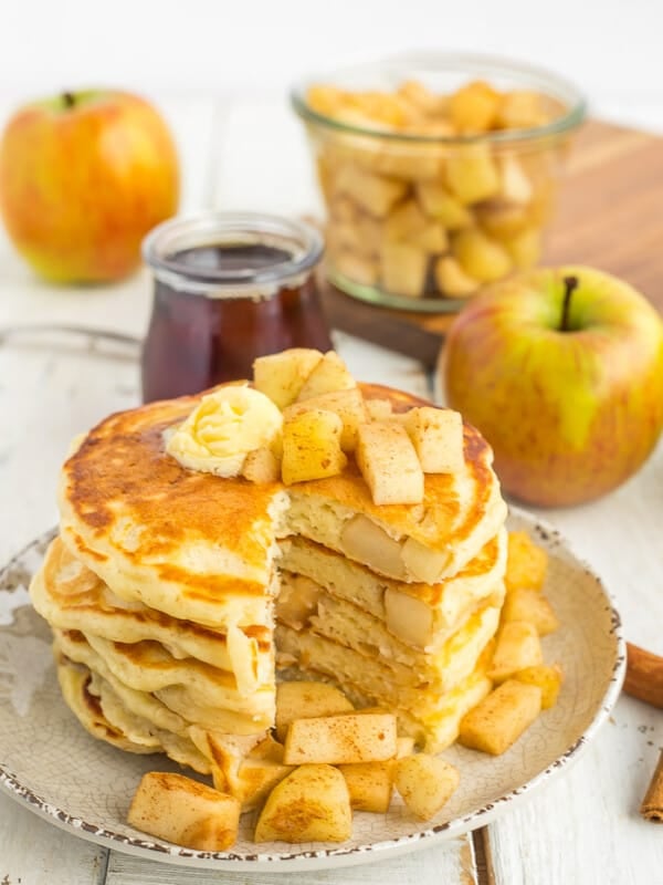 A stack of healthy apple pie pancakes with a slice cut out
