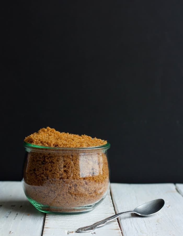 a bowl of homemade brown sugar in front of a black background