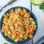 a bowl of instant pot quinoa with veggies on a white board with lime and cilantro