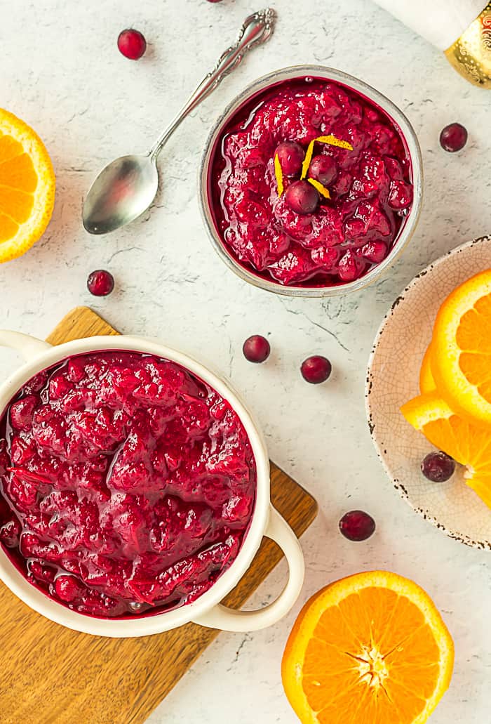 a bowl of orange cranberry sauce topped with fresh cranberries and orange zest