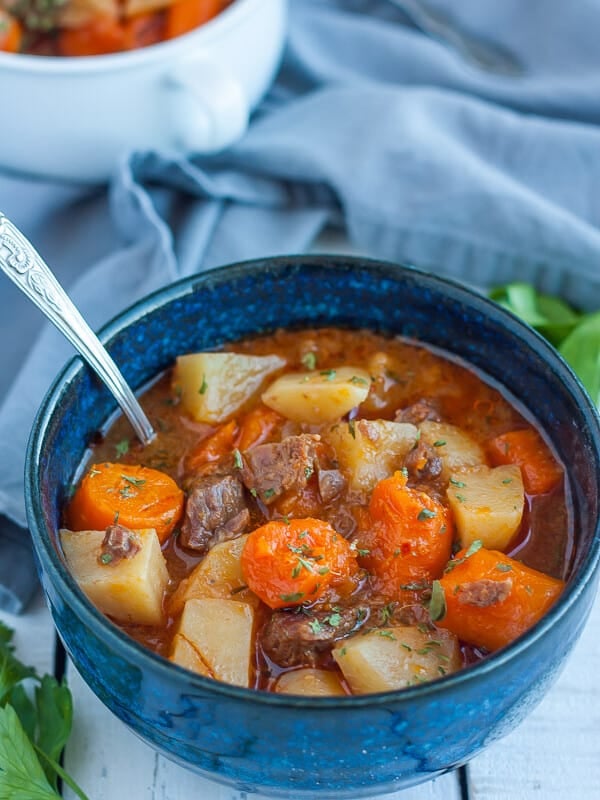 whole30 beef stew in a blue bowl with a spoon and a grey cloth