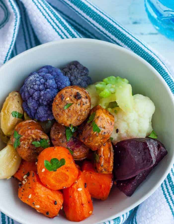 close up photo of veggies and sausage in a white bowl
