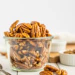 A glass bowl of stovetop candied pecans