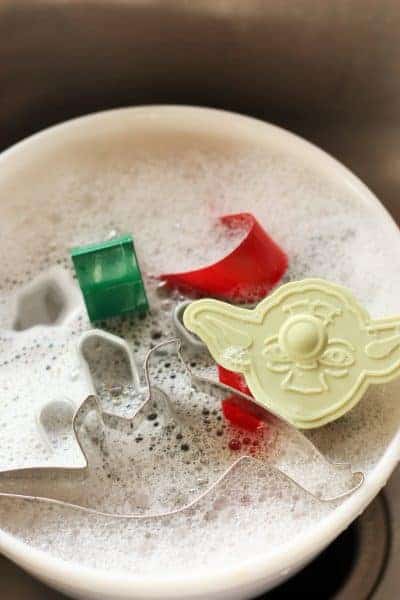 Soft Whole Wheat Sugar Cookies cookie cutters in a bowl of soapy water