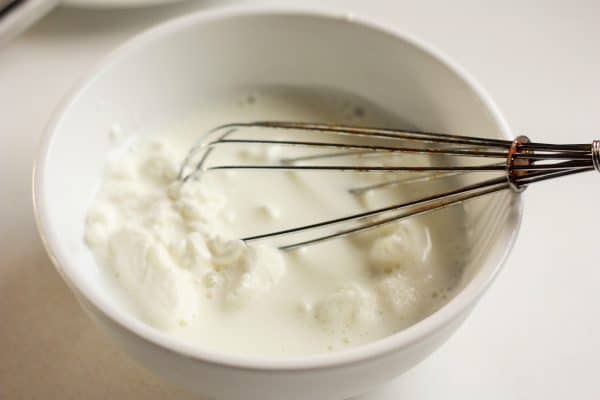 easy Instant pot yogurt | sustainablecooks.com a whisk in a bowl of milk and yogurt | sustainablecooks.com