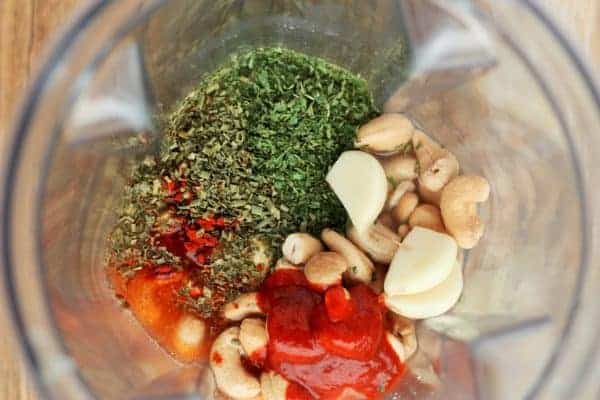 garlic, cashews, sriracha, and herbs in a vitamix