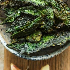 a bowl of cheesy kale chips with garlic
