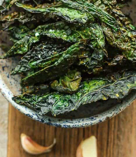 a bowl of cheesy kale chips with garlic