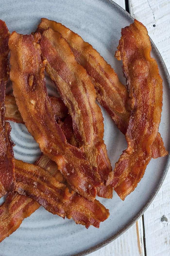 slices of cooked bacon on a grey plate