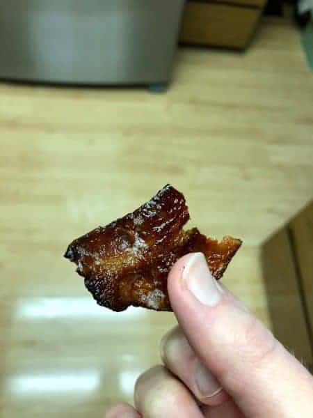 a hand holding bacon