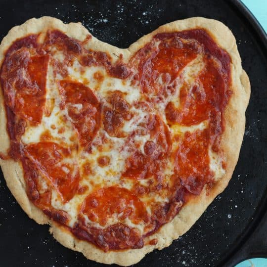 heart-shaped pizza on a cast iron pizza pan