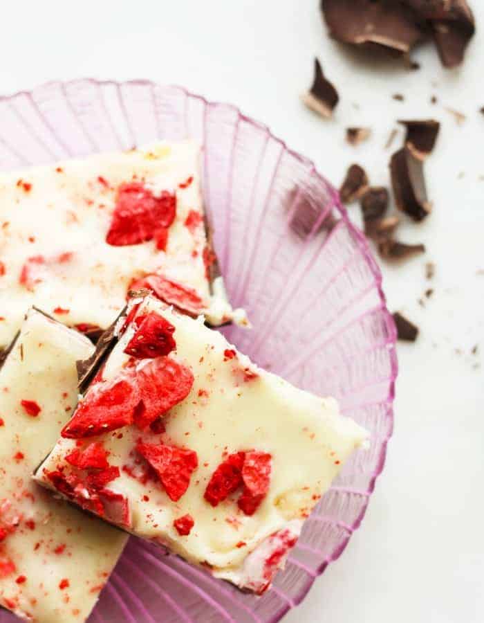 A pink plate with strawberry and chocolate bark