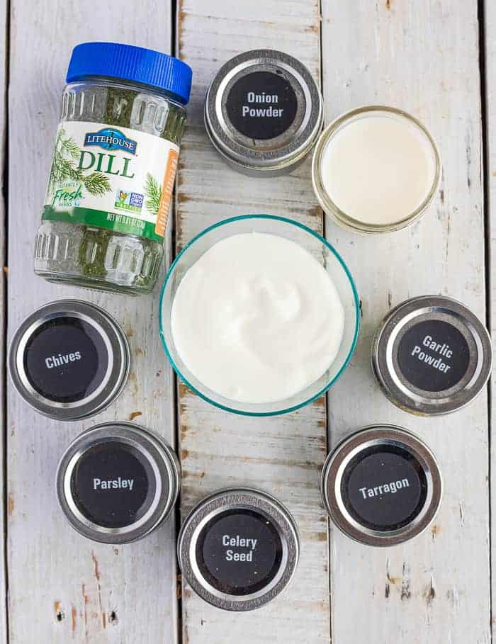 a bowl of greek yogurt, milk, and herbs on a white board