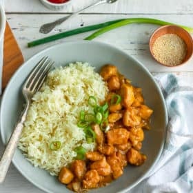 an overhead photo of a bowl of whole30 orange chicken and cauliflower rice