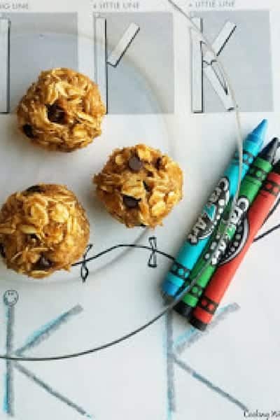 Three oat cookies sitting on a glass plate with three crayons