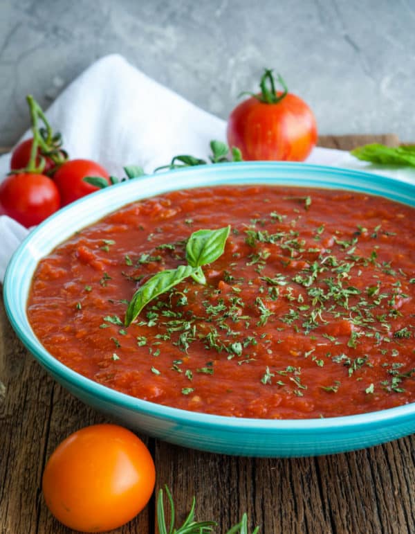 a bowl of crockpot spaghetti sauce with tomatoes and herbs