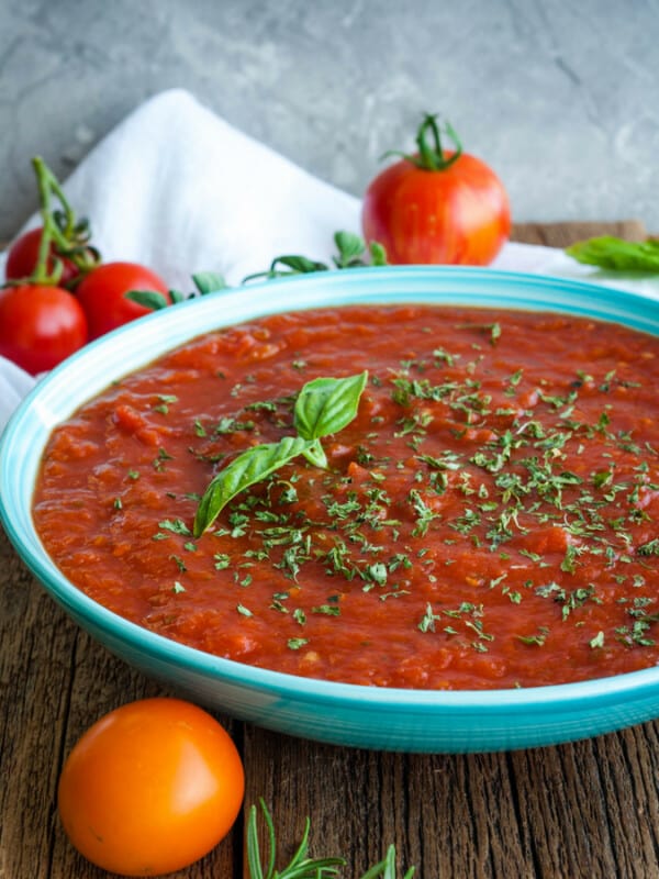 a bowl of crockpot spaghetti sauce with tomatoes and herbs