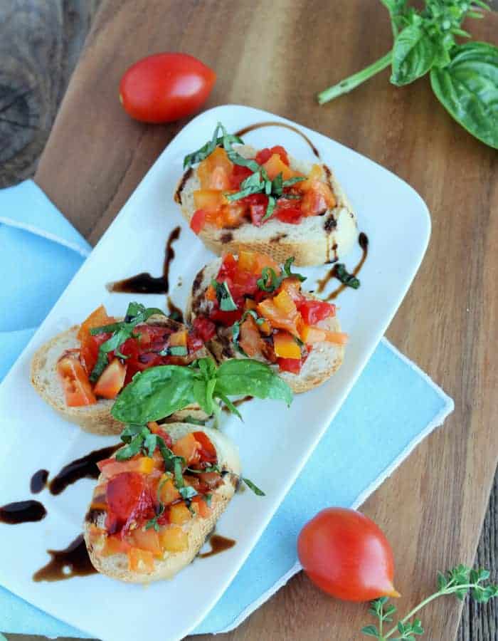 tomato bruschetta on a plate with a balsamic drizzle
