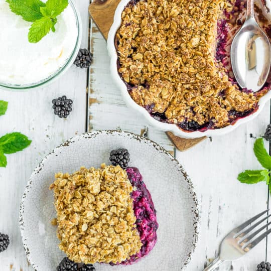a plate and dish of blackberry crisp with an oatmeal topping