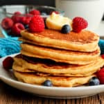 A stack of whole grain pancakes topped with berries