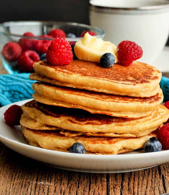 A stack of whole grain pancakes topped with berries