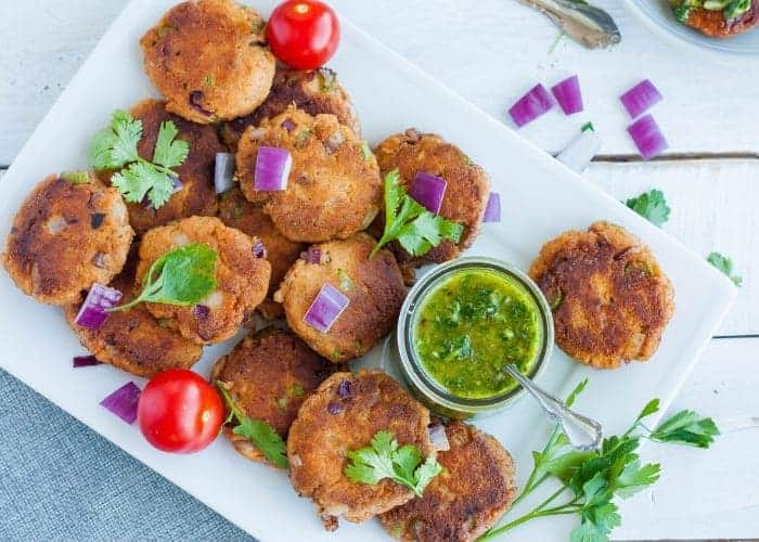 a platter of paleo salmon cakes with cilantro and chimichurri