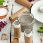 jars of deodorant with flowers, beeswax, and cardboard tubes