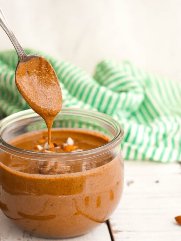 homemade cinnamon almond butter on a spoon with a jar