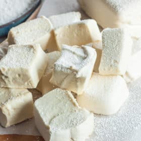 homemade healthy marshmallows on a wooden board with powdered sugar