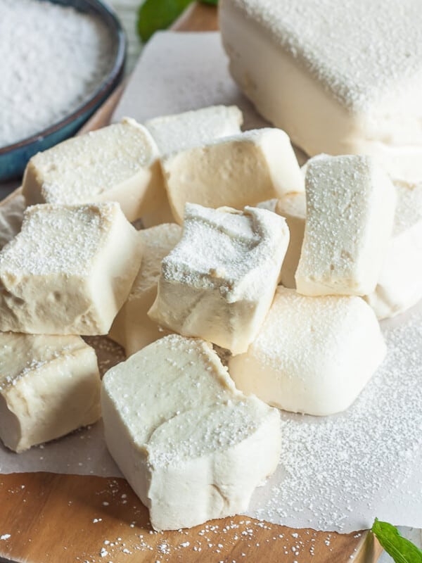 homemade healthy marshmallows on a wooden board with powdered sugar