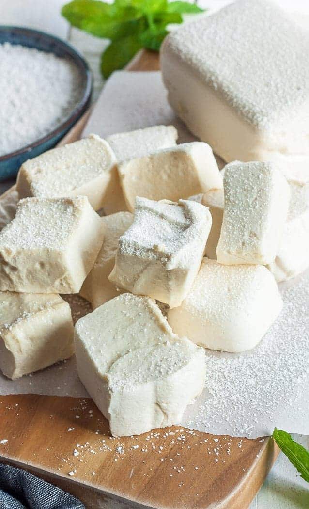 homemade healthy marshmallows on a wooden board with powdered sugar