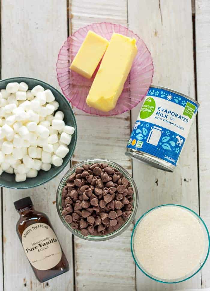 butter, chocolate chips, marshmallows, sugar, and evaporated milk on a white board