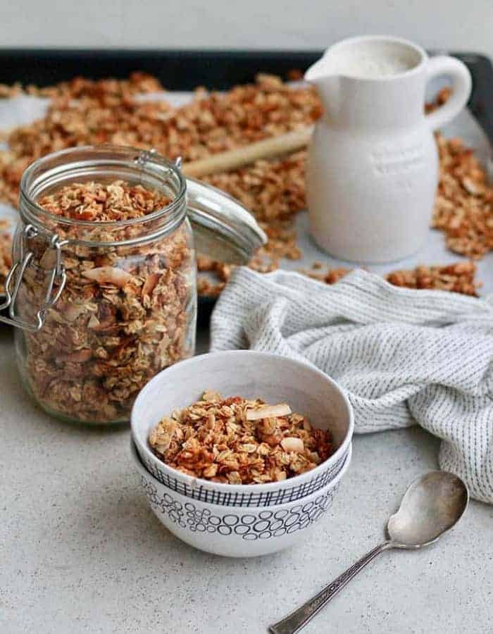 18 of the most delicious Make Ahead Christmas Morning Breakfasts. 18 easy ideas for overnight breakfast casseroles, healthy dishes, and sweet treats. #christmasbreakfast #christmasbrunch #makeheadbreakfast a bowl and jar of coconut banana granola for make ahead christmas morning breakfasts