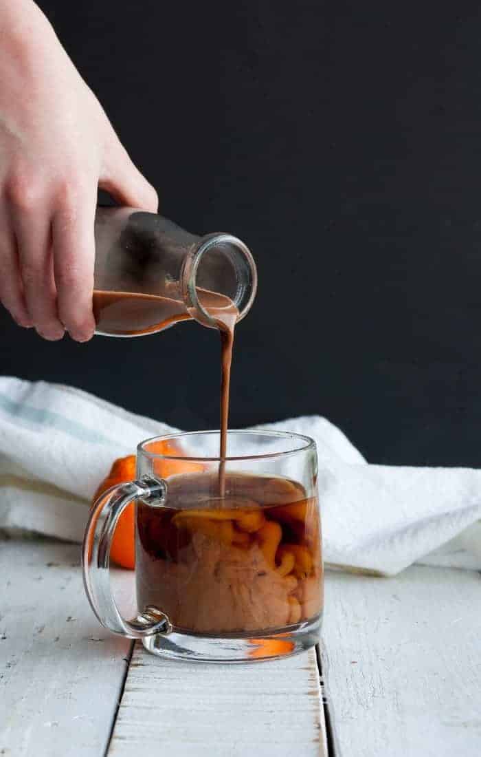 a pour shot showing chocolate coconut coffee creamer into a mug of coffee