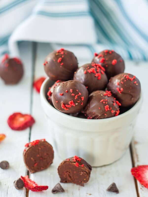 a bowl of dark chocolate truffles with strawberry flakes