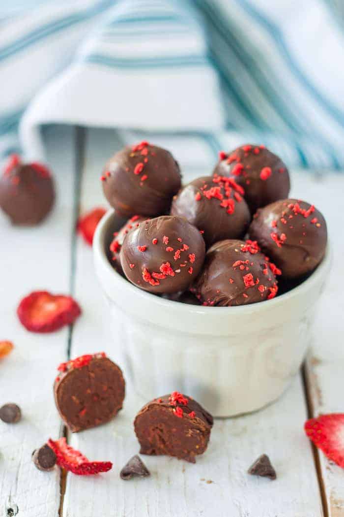 a bowl of dark chocolate truffles with strawberry flakes